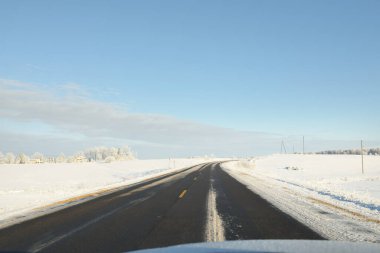 Karla kaplı orman ve kırsal alanda boş otoyol (asfalt yol). Kar sürükleniyor. Avrupa. Doğa, Noel tatilleri, uzak yerler, kış lastikleri, tehlikeli sürüş konsepti