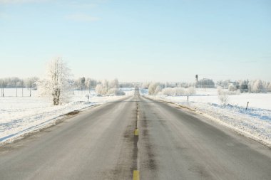 Karla kaplı orman ve kırsal alanda boş otoyol (asfalt yol). Kar sürükleniyor. Avrupa. Doğa, Noel tatilleri, uzak yerler, kış lastikleri, tehlikeli sürüş konsepti