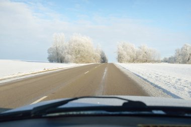 Karla kaplı orman ve kırsal alanda boş otoyol (asfalt yol). Kar sürükleniyor. Avrupa. Doğa, Noel tatilleri, uzak yerler, kış lastikleri, tehlikeli sürüş konsepti