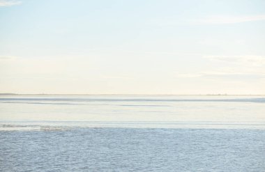 Gün batımında mavi orman gölü (nehir) panoramik hava manzarası. Yumuşak güneş ışığı, berrak gökyüzü, suya yansıyan yansımalar. Baharın başında. İdealist pastoral manzara. Doğa, çevre, ekoloji, eko-turizm
