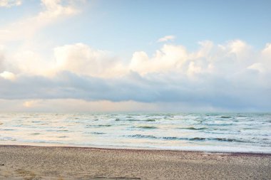 Fırtınadan sonra Baltık Denizi. Dramatik gökyüzü, parlayan bulutlar, yumuşak güneş ışığı. Dalgalar, su sıçratma. Resimli manzara, deniz manzarası, doğa. Panoramik görünüm