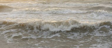 Fırtınadan sonra Baltık kıyıları. Gün batımı, yumuşak güneş ışığı. Su yüzeyi dokusu, çarpan dalgalar, sıçramalar, köpük. Resimli panoramik manzara. Idyllic deniz manzarası. Doğa, çevre, ekoloji temaları