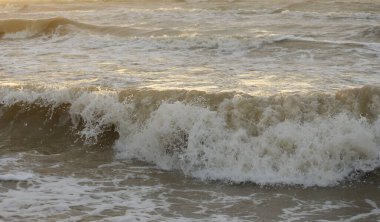 Fırtınadan sonra Baltık kıyıları. Gün batımı, yumuşak güneş ışığı. Su yüzeyi dokusu, çarpan dalgalar, sıçramalar, köpük. Resimli panoramik manzara. Idyllic deniz manzarası. Doğa, çevre, ekoloji temaları