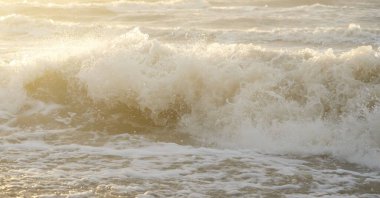 Fırtınadan sonra Baltık kıyıları. Gün batımı, yumuşak güneş ışığı. Su yüzeyi dokusu, çarpan dalgalar, sıçramalar, köpük. Resimli panoramik manzara. Idyllic deniz manzarası. Doğa, çevre, ekoloji temaları