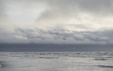 Fırtınadan sonra Baltık Denizi. Yumuşak günbatımı ışığı, çarpıcı parlayan bulutlar. Deniz manzarası, bulutlar, doğa. Panoramik manzara. Ekoloji, iklim değişikliği, hava durumu