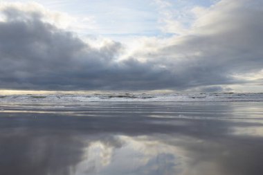 Fırtınadan sonra Baltık Denizi. Yumuşak günbatımı ışığı, çarpıcı parlayan bulutlar. Deniz manzarası, bulutlar, doğa. Sudaki yansımalar. Panoramik manzara. Ekoloji, iklim değişikliği, hava durumu