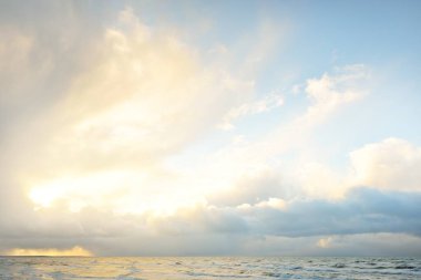 Fırtınadan sonra Baltık Denizi. Dramatik gökyüzü, parlayan bulutlar, yumuşak güneş ışığı. Dalgalar, su sıçratma. Resimli manzara, deniz manzarası, doğa. Panoramik görünüm