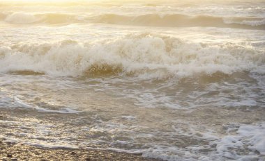 Fırtınadan sonra Baltık kıyıları. Gün batımı, yumuşak güneş ışığı. Su yüzeyi dokusu, çarpan dalgalar, sıçramalar, köpük. Resimli panoramik manzara. Idyllic deniz manzarası. Doğa, çevre, ekoloji temaları