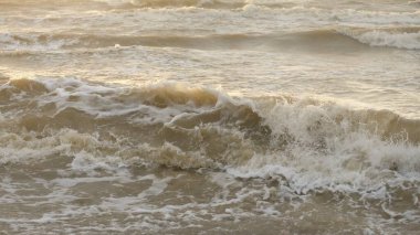 Fırtınadan sonra Baltık kıyıları. Gün batımı, yumuşak güneş ışığı. Su yüzeyi dokusu, çarpan dalgalar, sıçramalar, köpük. Resimli panoramik manzara. Idyllic deniz manzarası. Doğa, çevre, ekoloji temaları