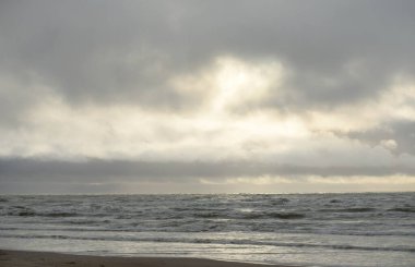 Fırtınadan sonra Baltık Denizi. Yumuşak günbatımı ışığı, çarpıcı parlayan bulutlar. Deniz manzarası, bulutlar, doğa. Panoramik manzara. Ekoloji, iklim değişikliği, hava durumu