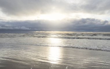 Fırtınadan sonra Baltık Denizi. Yumuşak günbatımı ışığı, çarpıcı parlayan bulutlar. Deniz manzarası, bulutlar, doğa. Panoramik manzara. Ekoloji, iklim değişikliği, hava durumu