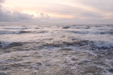 Fırtınadan sonra Baltık Denizi. Yumuşak günbatımı ışığı, çarpıcı parlayan bulutlar. Deniz manzarası, bulutlar, doğa. Panoramik manzara. Ekoloji, iklim değişikliği, hava durumu