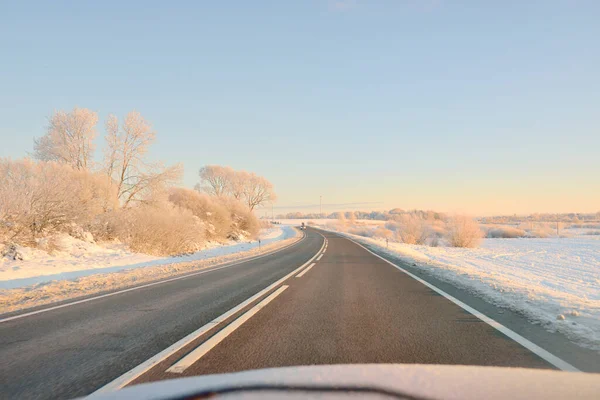 雪に覆われた森林やフィールド 農村部を介して空の高速道路 アスファルト道路 日の出 雪のドリフト ヨーロッパだ クリスマス休暇 遠隔地 冬のタイヤ 危険な運転の概念 — ストック写真
