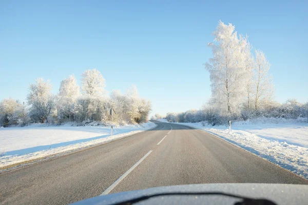 Karla kaplı orman ve kırsal alanda boş otoyol (asfalt yol). Kar sürükleniyor. Avrupa. Doğa, Noel tatilleri, uzak yerler, kış lastikleri, tehlikeli sürüş konsepti