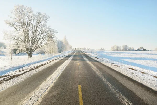 Karla kaplı orman ve kırsal alanda boş otoyol (asfalt yol). Kar sürükleniyor. Avrupa. Doğa, Noel tatilleri, uzak yerler, kış lastikleri, tehlikeli sürüş konsepti