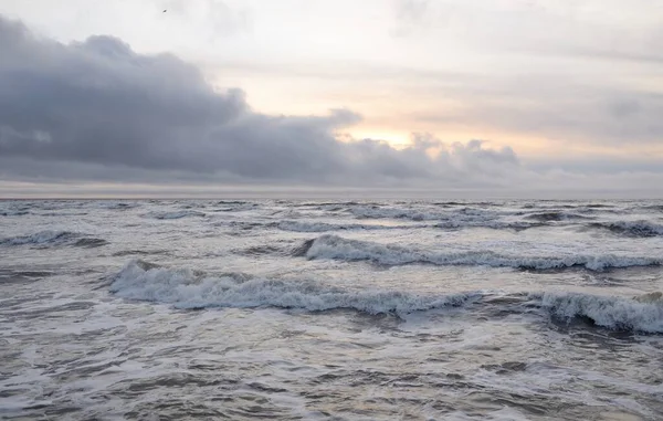 Fırtınadan sonra Baltık Denizi. Yumuşak günbatımı ışığı, çarpıcı parlayan bulutlar. Deniz manzarası, bulutlar, doğa. Panoramik manzara. Ekoloji, iklim değişikliği, hava durumu