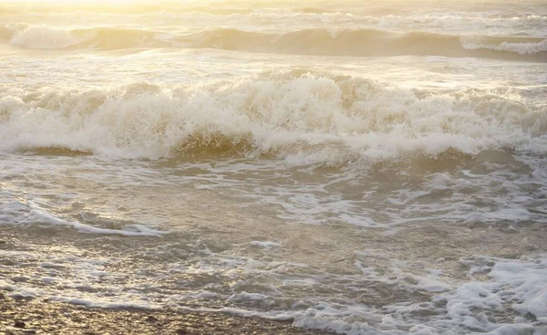 Fırtınadan sonra Baltık kıyıları. Gün batımı, yumuşak güneş ışığı. Su yüzeyi dokusu, çarpan dalgalar, sıçramalar, köpük. Resimli panoramik manzara. Idyllic deniz manzarası. Doğa, çevre, ekoloji temaları