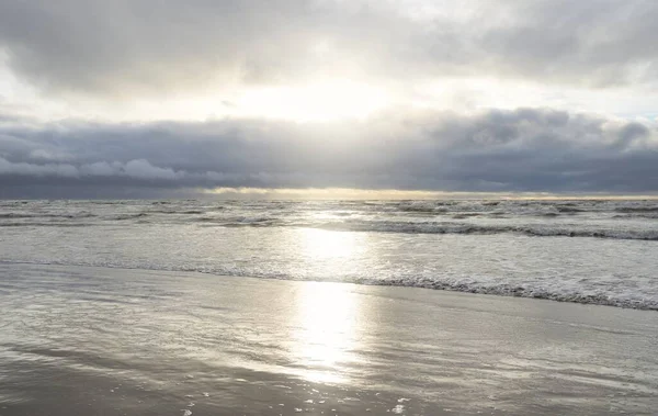 Fırtınadan sonra Baltık Denizi. Yumuşak günbatımı ışığı, çarpıcı parlayan bulutlar. Deniz manzarası, bulutlar, doğa. Panoramik manzara. Ekoloji, iklim değişikliği, hava durumu
