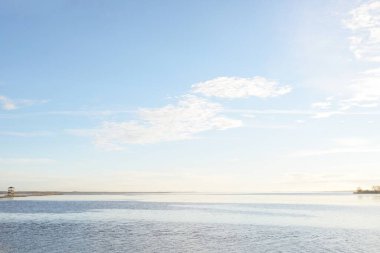 Gün batımında mavi orman gölü (nehir) panoramik hava manzarası. Yumuşak güneş ışığı, berrak gökyüzü, suya yansıyan yansımalar. Baharın başında. İdealist pastoral manzara. Doğa, çevre, ekoloji, eko-turizm
