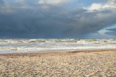 Fırtınadan sonra Baltık kıyıları (kum tepeleri, plaj). Dramatik gökyüzü, parlayan bulutlar. Resimli panoramik manzara. Doğa, çevre, ekoloji, eko-turizm, yürüyüş, keşif kavramları