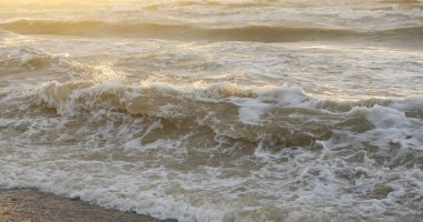 Fırtınadan sonra Baltık kıyıları. Gün batımı, yumuşak güneş ışığı. Su yüzeyi dokusu, çarpan dalgalar, sıçramalar, köpük. Resimli panoramik manzara. Idyllic deniz manzarası. Doğa, çevre, ekoloji temaları