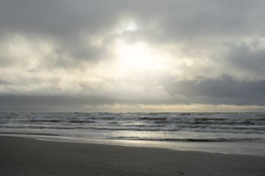 Fırtınadan sonra Baltık Denizi. Yumuşak günbatımı ışığı, çarpıcı parlayan bulutlar. Deniz manzarası, bulutlar, doğa. Panoramik manzara. Ekoloji, iklim değişikliği, hava durumu