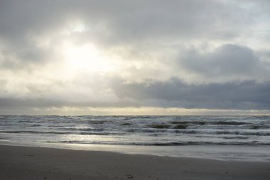 Fırtınadan sonra Baltık Denizi. Yumuşak günbatımı ışığı, çarpıcı parlayan bulutlar. Deniz manzarası, bulutlar, doğa. Panoramik manzara. Ekoloji, iklim değişikliği, hava durumu