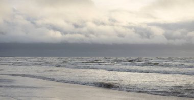 Fırtınadan sonra Baltık Denizi. Yumuşak günbatımı ışığı, çarpıcı parlayan bulutlar. Deniz manzarası, bulutlar, doğa. Panoramik manzara. Ekoloji, iklim değişikliği, hava durumu