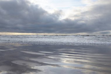 Fırtınadan sonra Baltık Denizi. Yumuşak günbatımı ışığı, çarpıcı parlayan bulutlar. Deniz manzarası, bulutlar, doğa. Sudaki yansımalar. Panoramik manzara. Ekoloji, iklim değişikliği, hava durumu