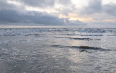 Fırtınadan sonra Baltık Denizi. Yumuşak günbatımı ışığı, çarpıcı parlayan bulutlar. Deniz manzarası, bulutlar, doğa. Panoramik manzara. Ekoloji, iklim değişikliği, hava durumu