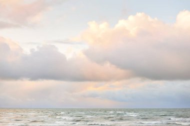 Fırtınadan sonra Baltık Denizi. Dramatik gökyüzü, parlayan bulutlar, yumuşak güneş ışığı. Dalgalar, su sıçratma. Resimli manzara, deniz manzarası, doğa. Panoramik görünüm