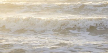 Fırtınadan sonra Baltık kıyıları. Gün batımı, yumuşak güneş ışığı. Su yüzeyi dokusu, çarpan dalgalar, sıçramalar, köpük. Resimli panoramik manzara. Idyllic deniz manzarası. Doğa, çevre, ekoloji temaları