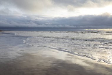 Fırtınadan sonra Baltık Denizi. Yumuşak günbatımı ışığı, çarpıcı parlayan bulutlar. Deniz manzarası, bulutlar, doğa. Panoramik manzara. Ekoloji, iklim değişikliği, hava durumu