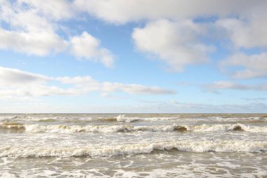 Fırtınadan sonra Baltık Denizi. Dramatik gökyüzü, parlayan bulutlar, yumuşak güneş ışığı. Dalgalar, su sıçratma. Resimli manzara, deniz manzarası, doğa. Panoramik görünüm