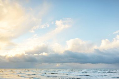 Fırtınadan sonra Baltık Denizi. Dramatik gökyüzü, parlayan bulutlar, yumuşak güneş ışığı. Dalgalar, su sıçratma. Resimli manzara, deniz manzarası, doğa. Panoramik görünüm