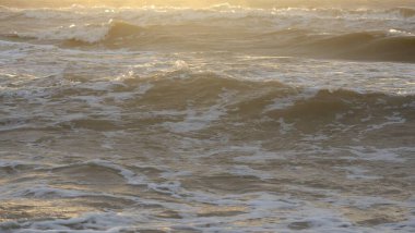 Fırtınadan sonra Baltık kıyıları. Gün batımı, yumuşak güneş ışığı. Su yüzeyi dokusu, çarpan dalgalar, sıçramalar, köpük. Resimli panoramik manzara. Idyllic deniz manzarası. Doğa, çevre, ekoloji temaları