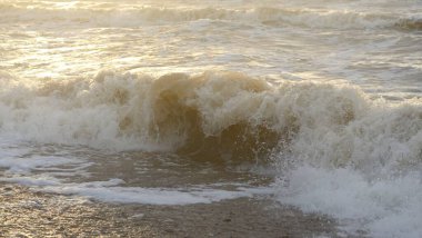 Fırtınadan sonra Baltık kıyıları. Gün batımı, yumuşak güneş ışığı. Su yüzeyi dokusu, çarpan dalgalar, sıçramalar, köpük. Resimli panoramik manzara. Idyllic deniz manzarası. Doğa, çevre, ekoloji temaları