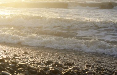 Fırtınadan sonra Baltık kıyıları. Gün batımı, yumuşak güneş ışığı. Su yüzeyi dokusu, çarpan dalgalar, sıçramalar, köpük. Resimli panoramik manzara. Idyllic deniz manzarası. Doğa, çevre, ekoloji temaları