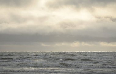 Fırtınadan sonra Baltık Denizi. Yumuşak günbatımı ışığı, çarpıcı parlayan bulutlar. Deniz manzarası, bulutlar, doğa. Panoramik manzara. Ekoloji, iklim değişikliği, hava durumu