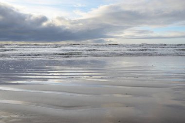 Fırtınadan sonra Baltık Denizi. Yumuşak günbatımı ışığı, çarpıcı parlayan bulutlar. Deniz manzarası, bulutlar, doğa. Panoramik manzara. Ekoloji, iklim değişikliği, hava durumu