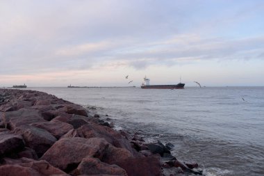 Kargo gemisi gün batımında limana varacak. Baltık Denizi. Yük taşımacılığı, küresel iletişim, lojistik, sanayi