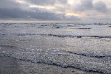 Fırtınadan sonra Baltık Denizi. Yumuşak günbatımı ışığı, çarpıcı parlayan bulutlar. Deniz manzarası, bulutlar, doğa. Panoramik manzara. Ekoloji, iklim değişikliği, hava durumu