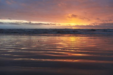 Fırtınadan sonra gün batımında Baltık Denizi. Dramatik gökyüzü, parlayan bulutlar, dofty altın güneş ışığı, dalgalar, fışkıran su. Resimli panoramik manzara. Doğa, çevre, ekoloji