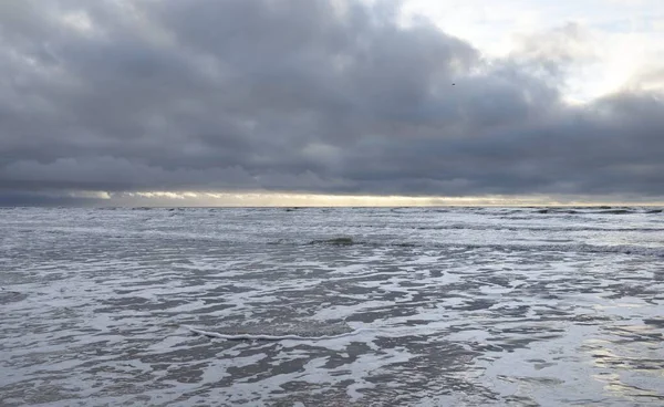Fırtınadan sonra Baltık Denizi. Yumuşak günbatımı ışığı, çarpıcı parlayan bulutlar. Deniz manzarası, bulutlar, doğa. Sudaki yansımalar. Panoramik manzara. Ekoloji, iklim değişikliği, hava durumu