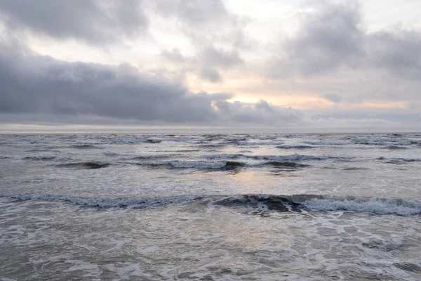Fırtınadan sonra Baltık Denizi. Yumuşak günbatımı ışığı, çarpıcı parlayan bulutlar. Deniz manzarası, bulutlar, doğa. Panoramik manzara. Ekoloji, iklim değişikliği, hava durumu