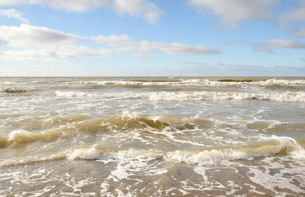Fırtınadan sonra Baltık Denizi. Dramatik gökyüzü, parlayan bulutlar, yumuşak güneş ışığı. Dalgalar, su sıçratma. Resimli manzara, deniz manzarası, doğa. Panoramik görünüm