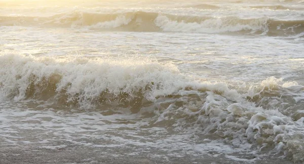 Fırtınadan sonra Baltık kıyıları. Gün batımı, yumuşak güneş ışığı. Su yüzeyi dokusu, çarpan dalgalar, sıçramalar, köpük. Resimli panoramik manzara. Idyllic deniz manzarası. Doğa, çevre, ekoloji temaları