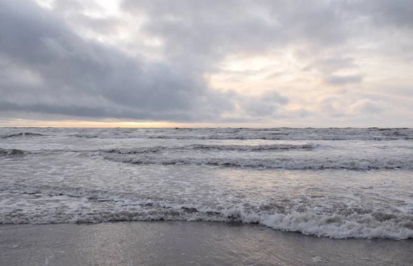 Fırtınadan sonra Baltık Denizi. Yumuşak günbatımı ışığı, çarpıcı parlayan bulutlar. Deniz manzarası, bulutlar, doğa. Sudaki yansımalar. Panoramik manzara. Ekoloji, iklim değişikliği, hava durumu