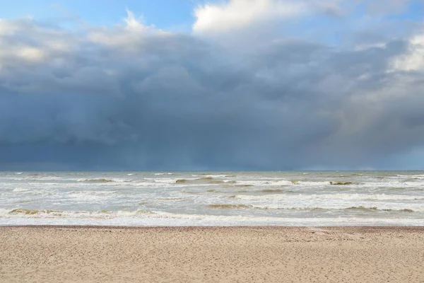 Fırtınadan sonra Baltık kıyıları (kum tepeleri, plaj). Dramatik gökyüzü, parlayan bulutlar. Resimli panoramik manzara. Doğa, çevre, ekoloji, eko-turizm, yürüyüş, keşif kavramları