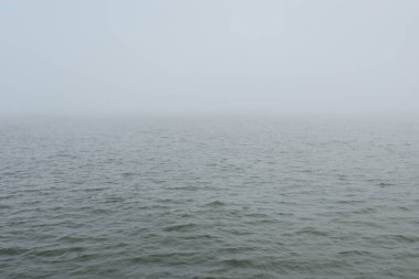 Sis içindeki Baltık Denizi. Dalgalar, su sıçratma, fırtına. Doğal dokular. Resimli panoramik monokrom manzarası, deniz manzarası. Doğa, çevre, sert hava, tehlike